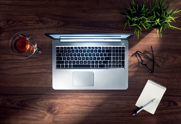 Close-up van leuke zilveren laptop op houten schrijftafel toppunt — Stockfoto