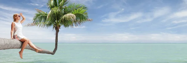 Vista de la agradable joven sentada en la palma de la playa tropical. banner . — Foto de Stock