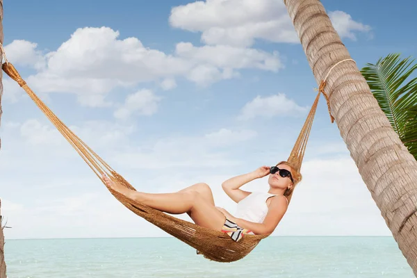 Veduta di bella giovane signora oscillante in hummock sulla spiaggia tropicale — Foto Stock