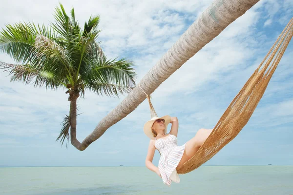 Weergave van mooie jonge dame swingend in hummock op tropisch strand — Stockfoto