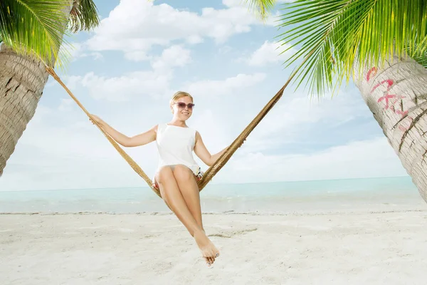 Blick auf hübsche junge Dame, die in einer Buckelmatte am tropischen Strand schwingt — Stockfoto