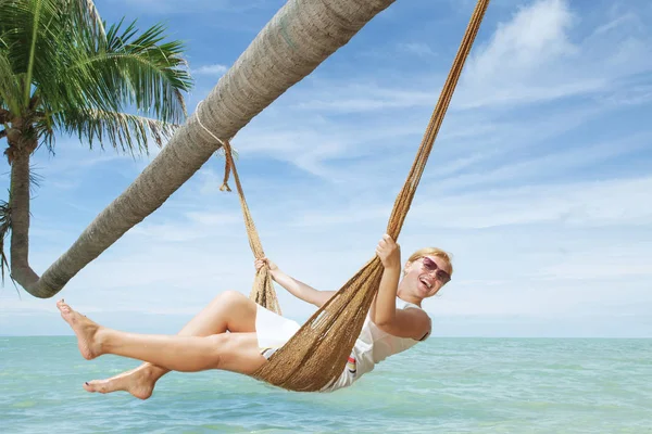 Vista de menina agradável balançando em hummock na praia tropical — Fotografia de Stock