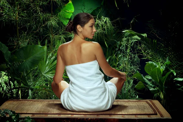 Vue d'une belle jeune femme méditant dans un environnement tropical spa — Photo