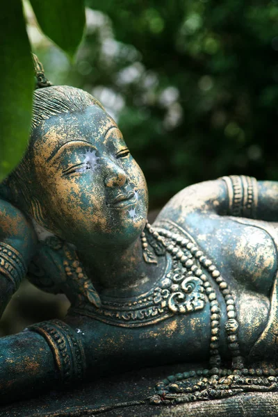 Закрыть вид на старую бетонную статую Будды на зеленой спине — стоковое фото