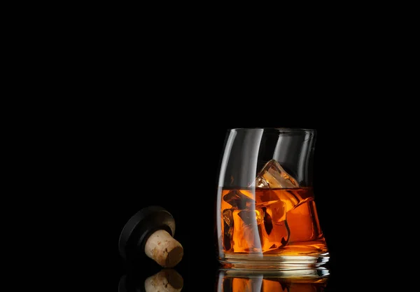 Close up view of glass of  whiskey and cork on black back — Stock Photo, Image