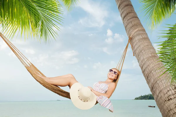 Vue de belle jeune femme balançant en hummock sur la plage tropicale — Photo