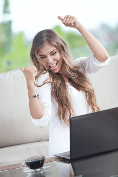 Portret van de jonge vrouw zittend op de Bank met laptop in zomer huis omgeving — Stockfoto