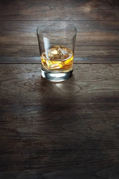 Close up view of  glass with ice and whiskey on wooden background — Stock Photo, Image