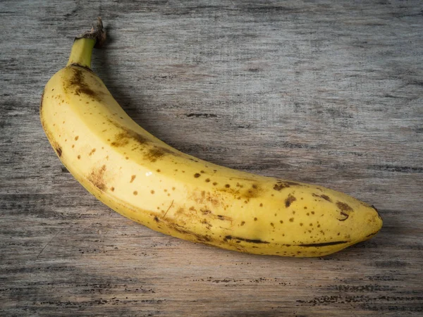 ripe lonely banana lying on an old wooden table