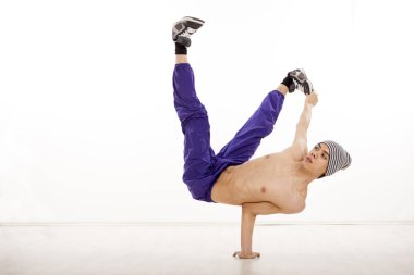Bir yandan oturan genç bir üstsüz erkek Streetdance konumunu