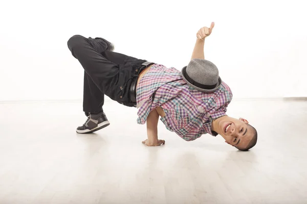 Gelukkig jonge mannelijke danser zittend op zijn hoofd glimlachen — Stockfoto