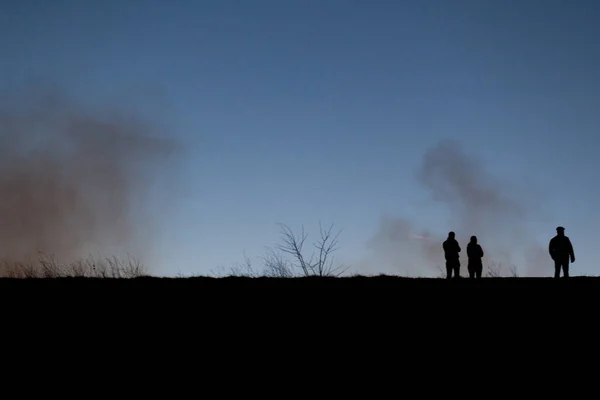 パルクナチュラル ヴァカレスティの植生に広がる火を見ている人々のシルエット 当局者達は 3ヘクタール以上が焼失し 風によって扇動されたと言います ブカレスト南部のデルタ ヴァカレスティ ルーマニア ストック写真