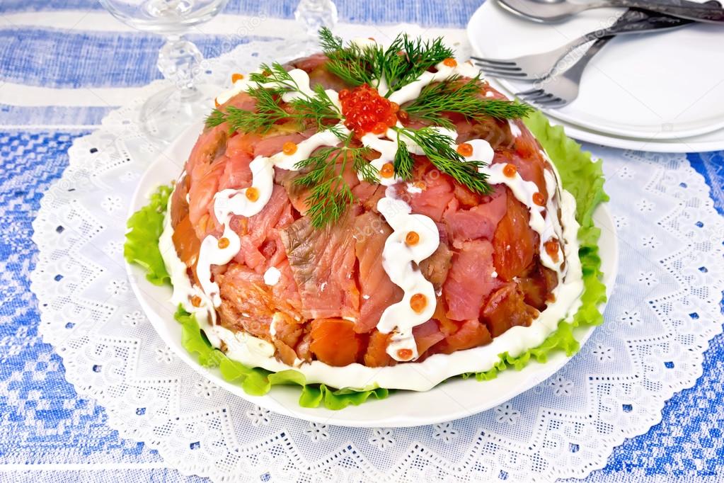 Salad with salmon in plate on blue tablecloth