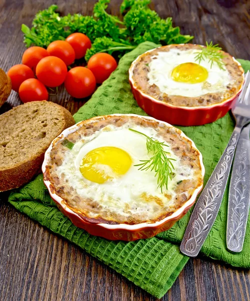 Tartlet meat with egg in pan on dark board — Stock Photo, Image
