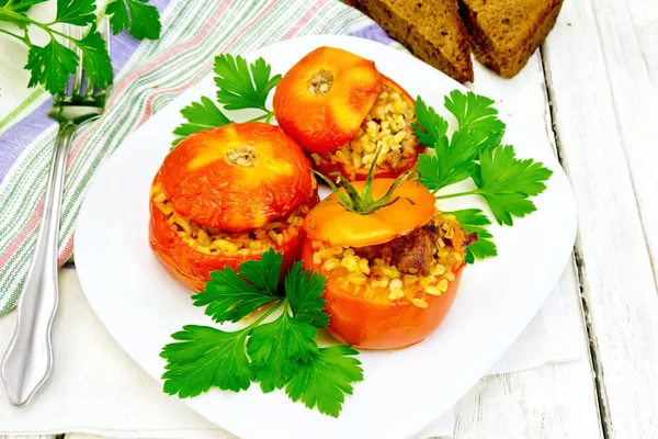 Tomates rellenos de bulgur y perejil en plato sobre mesa — Foto de Stock