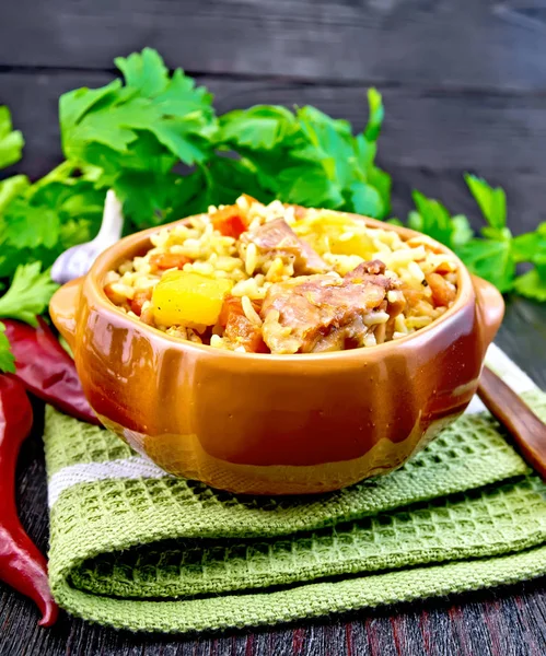 Rice with chicken and zucchini in clay bowl on board — Stock Photo, Image