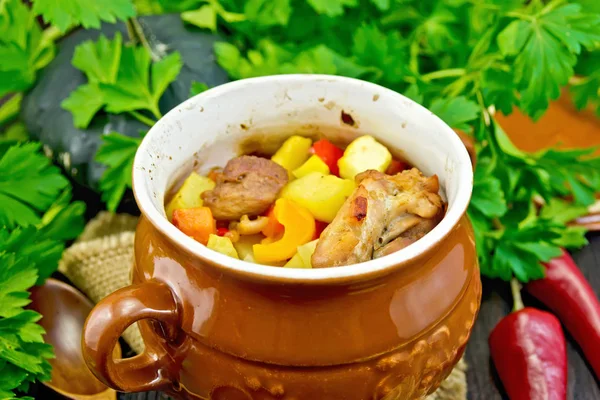 Carne assada e verduras no pote no conselho escuro — Fotografia de Stock