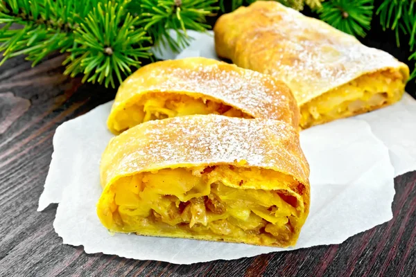 Strudel pumpkin and apple with pine branches on dark board — Stock Photo, Image