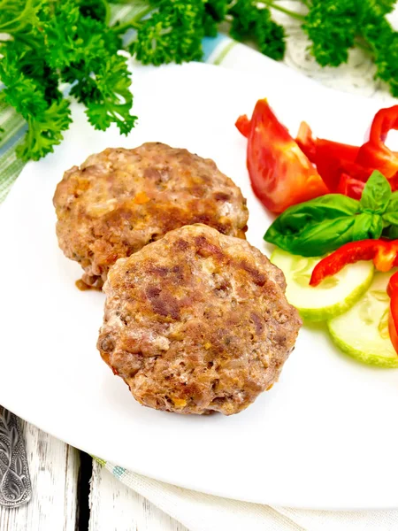 Cutlets stuffed with basil in white plate on board — Stock Photo, Image