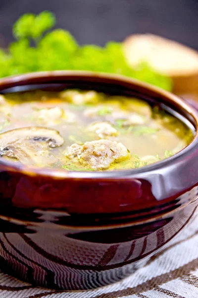 Sopa com almôndegas e cogumelos em tigela de barro no tabuleiro escuro — Fotografia de Stock