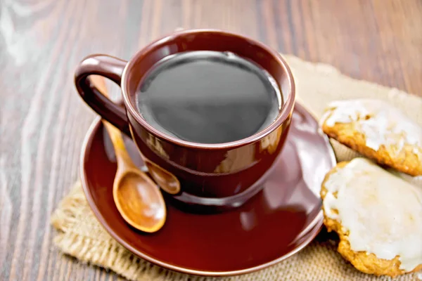Café em xícara marrom com biscoitos na placa escura — Fotografia de Stock
