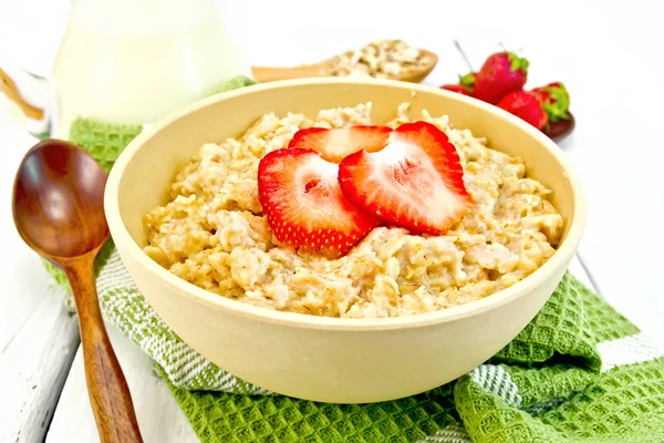 Oatmeal with strawberries on light board — Stock Photo, Image