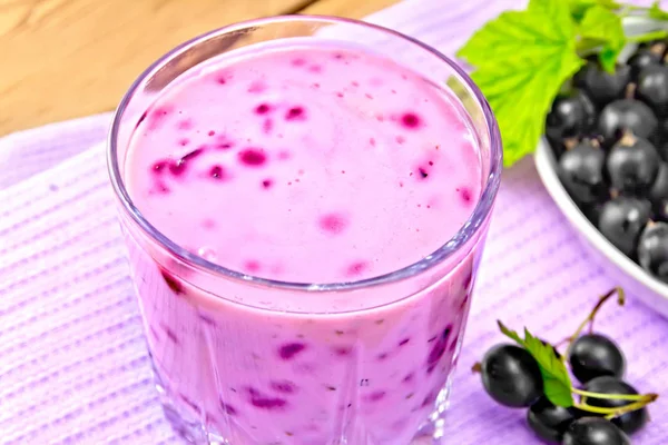 Milkshake with black currants in glass on wooden board — Stock Photo, Image