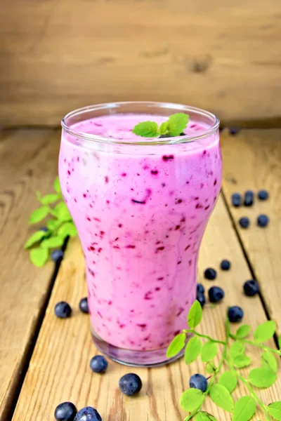 Milchshake mit Blaubeeren im Glas auf Holztisch — Stockfoto