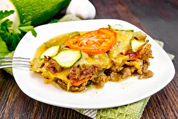 Casserole from minced meat and zucchini in plate on dark board — Stock Photo, Image