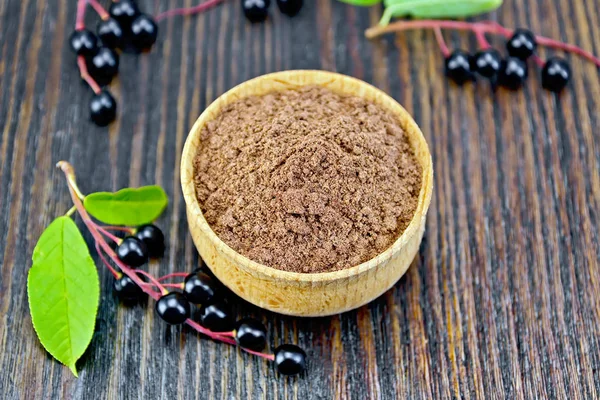 Harina de cereza pájaro en tazón con bayas a bordo oscuro — Foto de Stock