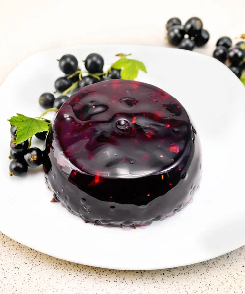 Jelly from black currant with berries in plate on table — Stock Photo, Image