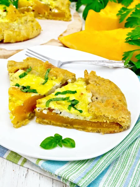 Pie of pumpkin and basil in plate on light board — Stock Photo, Image