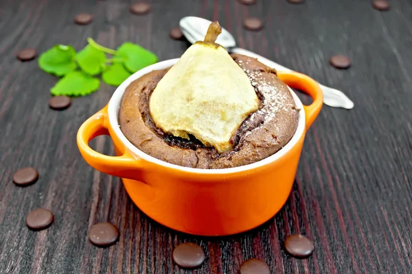 Cake with chocolate and pear in red bowl on dark board — Stock Photo, Image