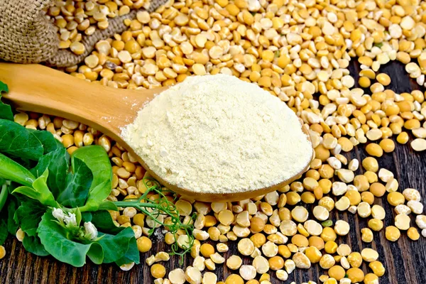 Flour pea in spoon on dark board — Stock Photo, Image