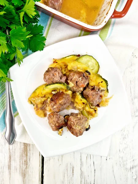 Meatballs with zucchini and nuts in plate on board top — Stock Photo, Image