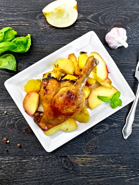 Entenkeule mit Apfel und Kartoffeln im Teller an Bord — Stockfoto