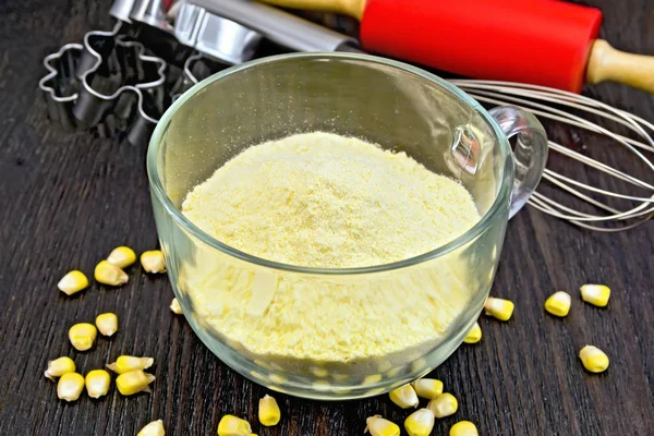 Flour corn in glass cup on dark board — Stock Photo, Image