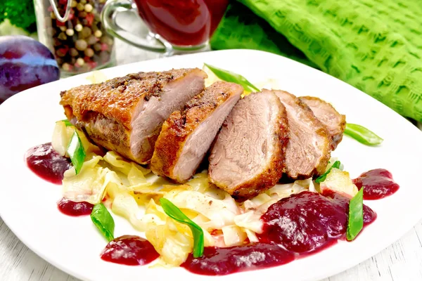 Poitrine de canard avec sauce prune et chou dans une assiette à bord — Photo