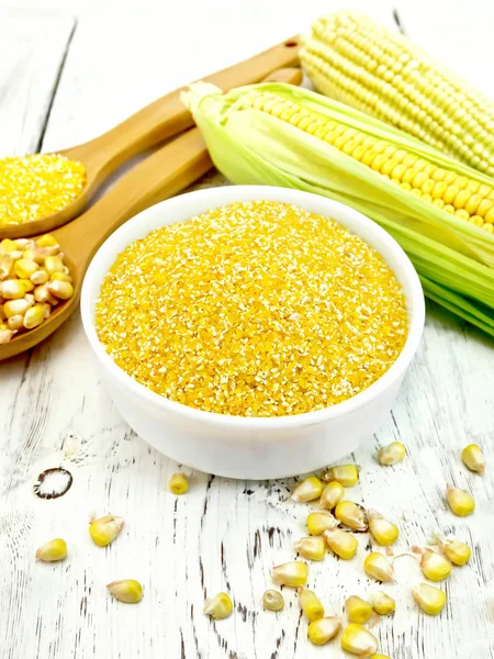 Sémola de maíz en tazón con mazorcas en tablero ligero — Foto de Stock