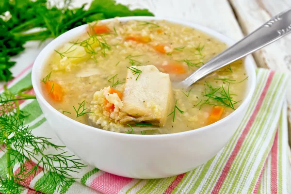 Soup fish with millet and spoon on board — Stock Photo, Image