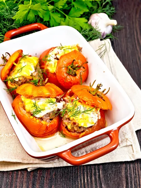 Tomates rellenos de arroz y carne en brasero a bordo oscuro —  Fotos de Stock