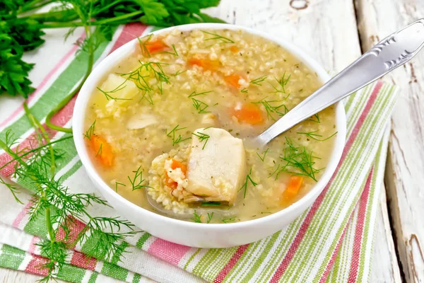 Sopa de pescado con mijo y cuchara sobre tabla ligera — Foto de Stock
