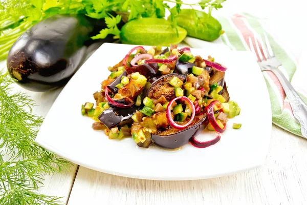 Sallad från aubergine och gurka med rödlök i plattan på ligh — Stockfoto