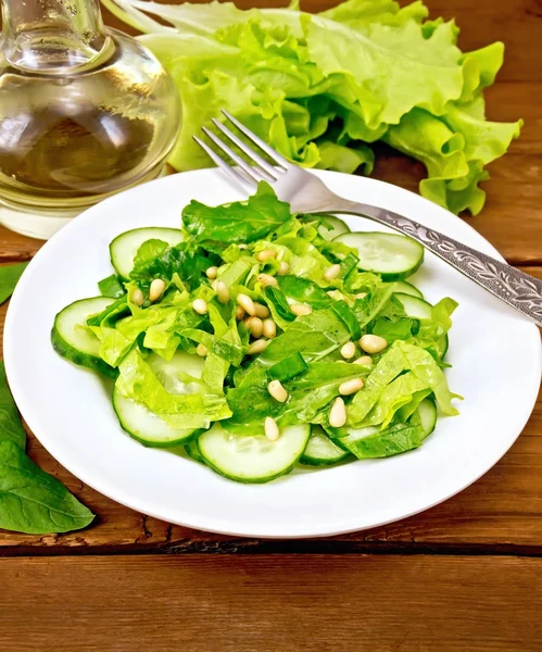 Salad from spinach and cucumbers with fork on wooden table — Stock Photo, Image