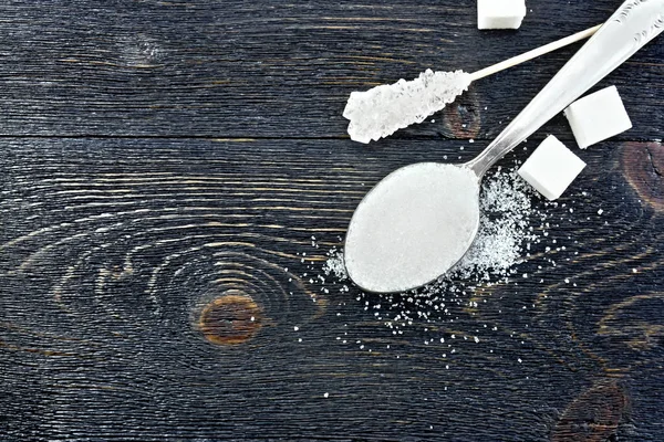 Açúcar branco na colher no topo da placa preta — Fotografia de Stock