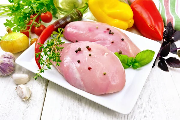 Pechuga de pollo cruda en plato con verduras y especias en la mesa — Foto de Stock