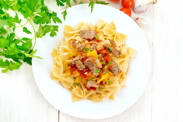 Farfalle with turkey and vegetables on light board top — Stock Photo, Image