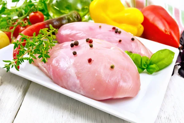 Pechuga de pollo cruda en plato con verduras en la mesa — Foto de Stock