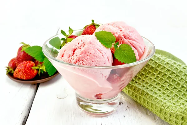 Клубничное мороженое в стакане с ягодами на борту — стоковое фото