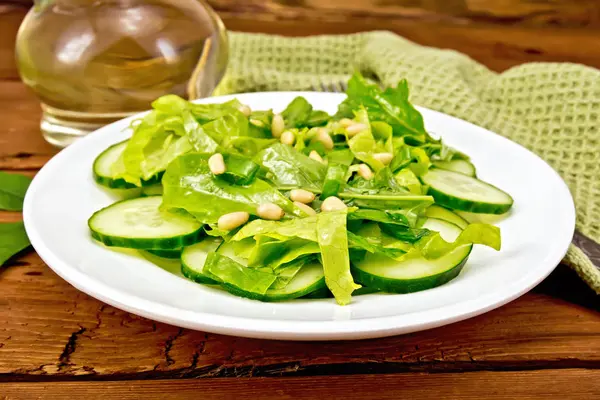 Salad from spinach and cucumber with napkin on board — Stock Photo, Image